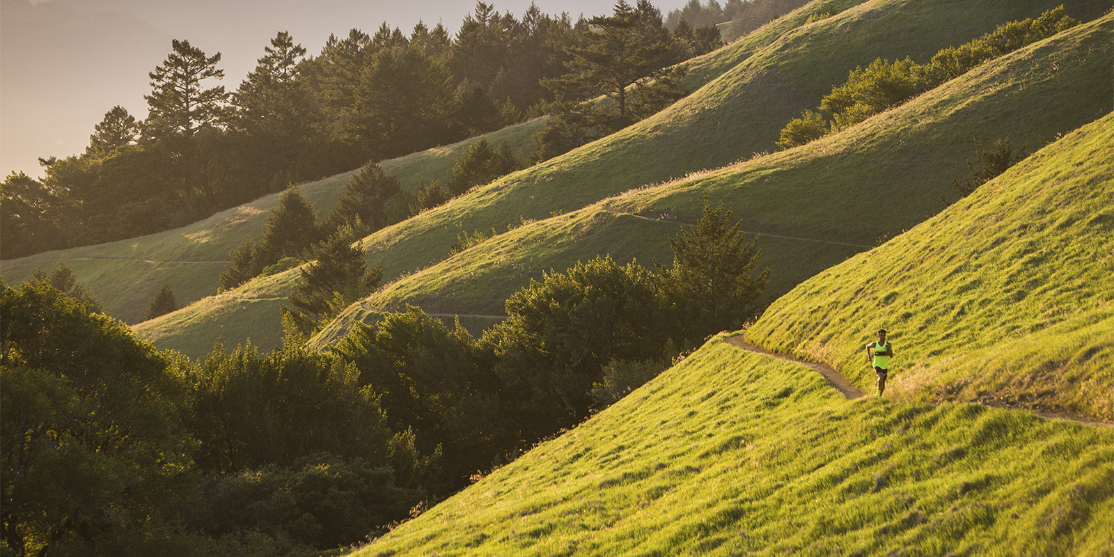 a man running through a hill trail